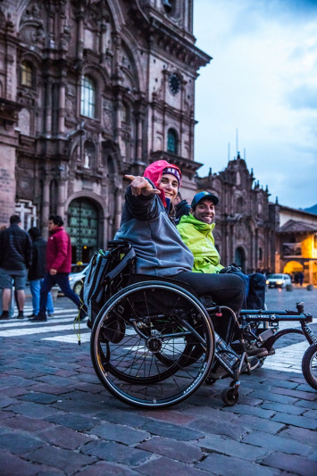 Two wheelchair users pose for a picture in the heart of Cusco