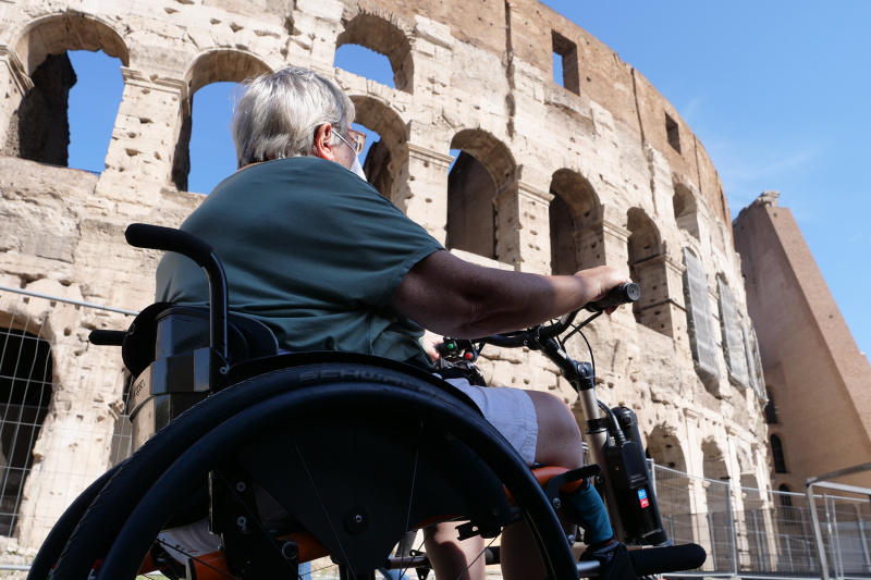 A person in a wheelchair inside the arena of the Colosseum