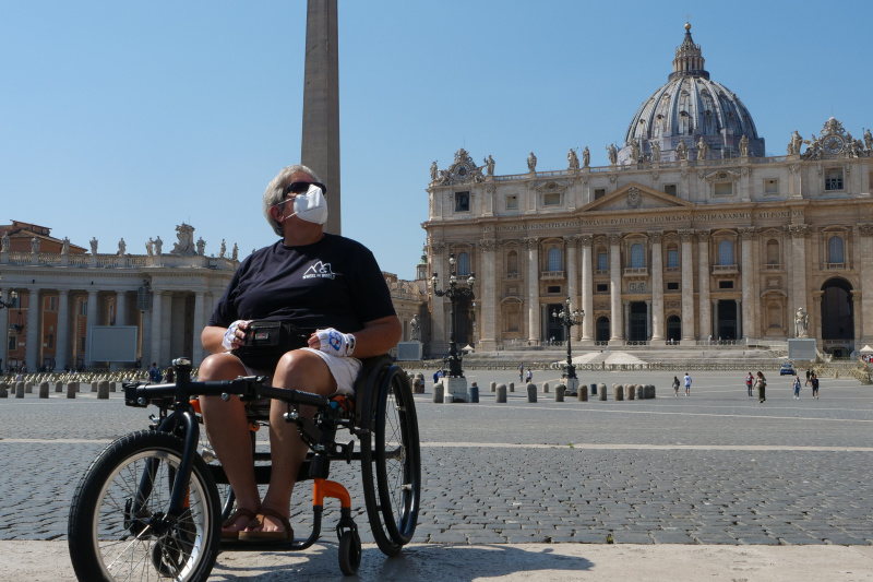 A person in a wheelchair poses for a photo in Saint Peter's Square in Rome