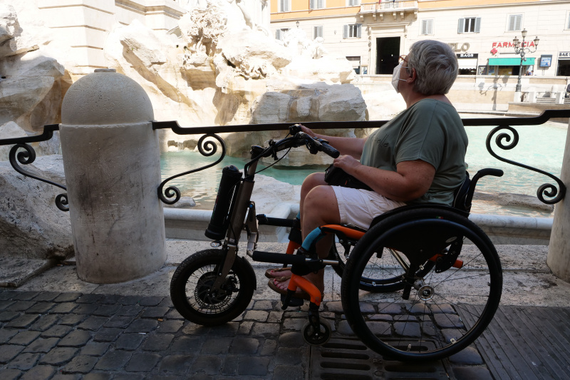A person in a wheelchair looks at the Trevi Fountains