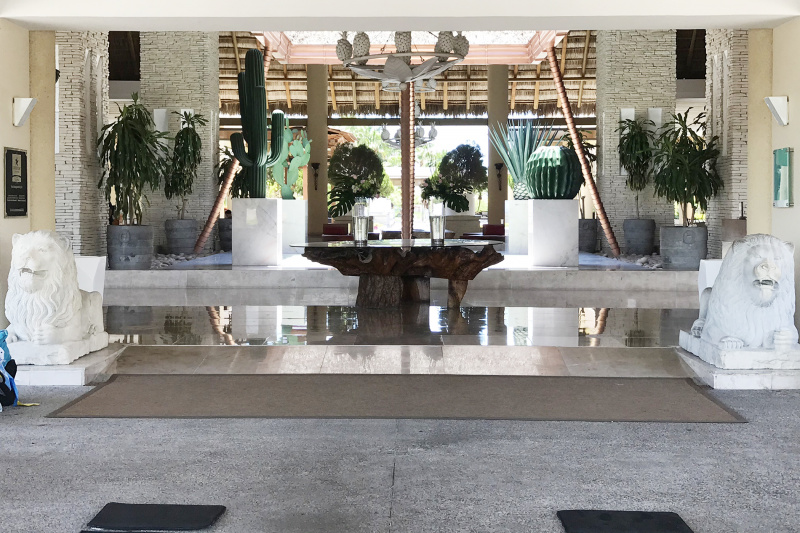 Lobby and entryway with large, livewood table, statues, and a ramp.