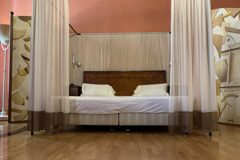 Junior room has a queen sized bed, two bedside tables and lamps