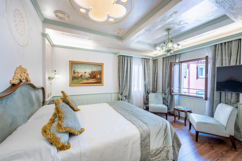 The room has 1 queen-size bed with nightstands.There are 2  chairs a small table and a wall-mounted TV.