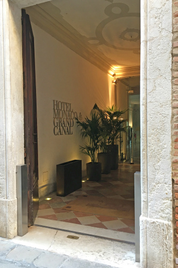 Access to the hotel is through wide wooden doors from the sidewalk.