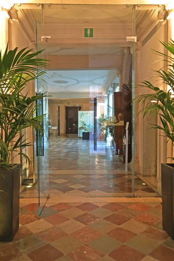 There are glass doors opening onto a spacious lobby.