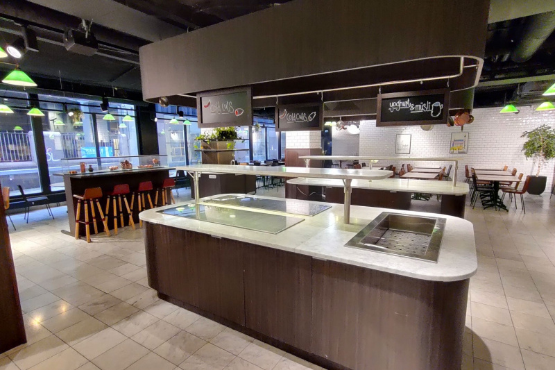 Dining area with hot plates at an accessible height, standing height seating, and seating at an accessible height with city views