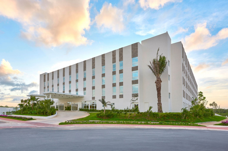 Exterior view of multistoried City Express Suites Cancún Aeropuerto Riviera