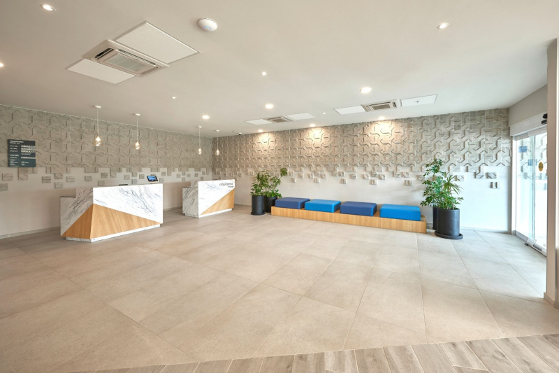 Hotel lobby with minimlaist design hosts two reception desks and bench seating