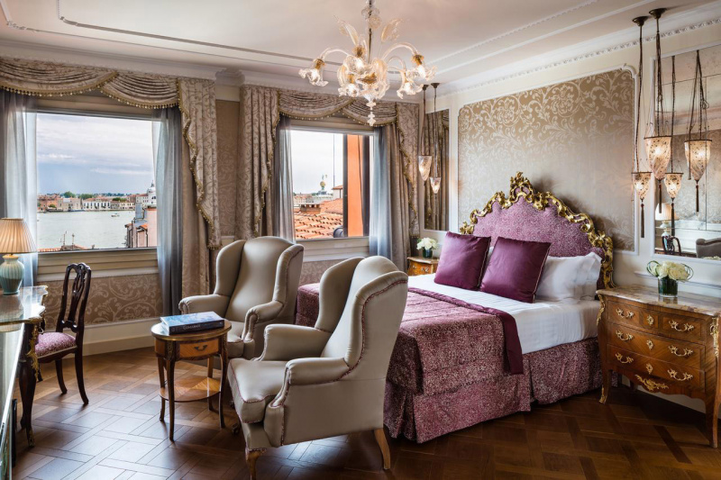 King-size bed, two bedside tables, hanging lamps, and two large windows