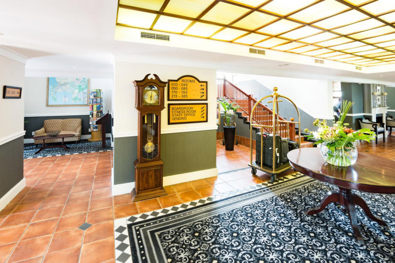 Lobby with ornate decor, a lounge, stairway, and signage that directs to areas throughout the hotel