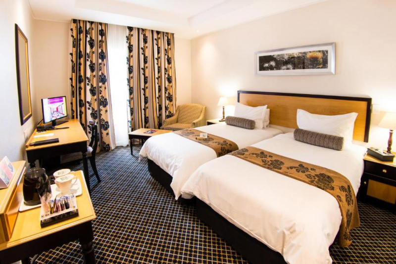Accessible room with twin beds, bedside tables, and work desk