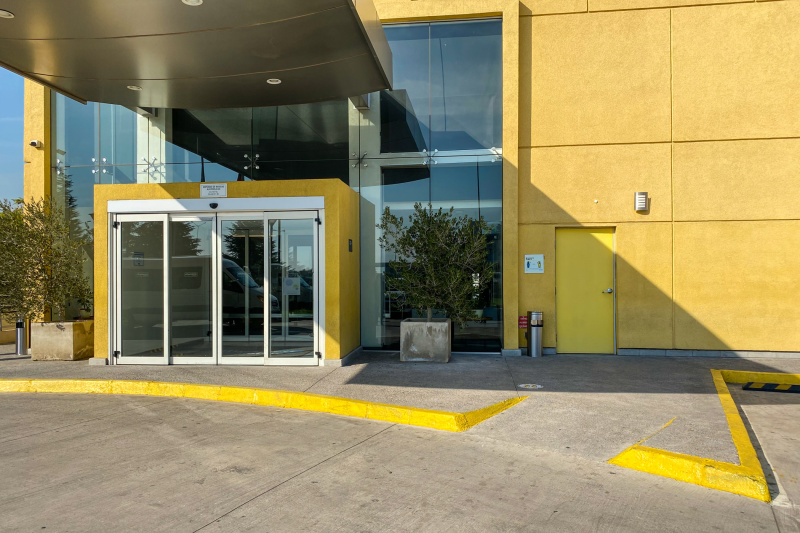 Hotel entrance with a stair and a ramp.