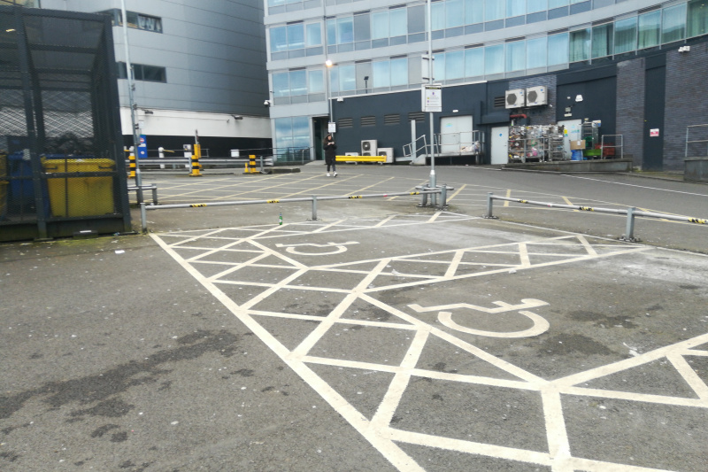 Car park in front of the hotel with accessible  parking spaces.