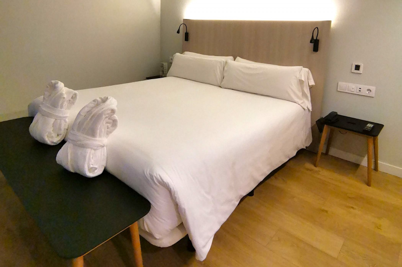 Deluxe double room with a bench and wide space on the side of the bed.