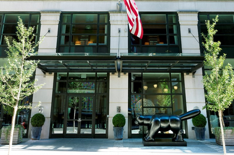 Hotel building with modern statue and flag