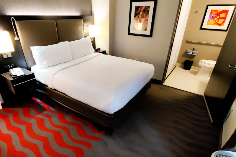 Guestroom with bed and bathroom door