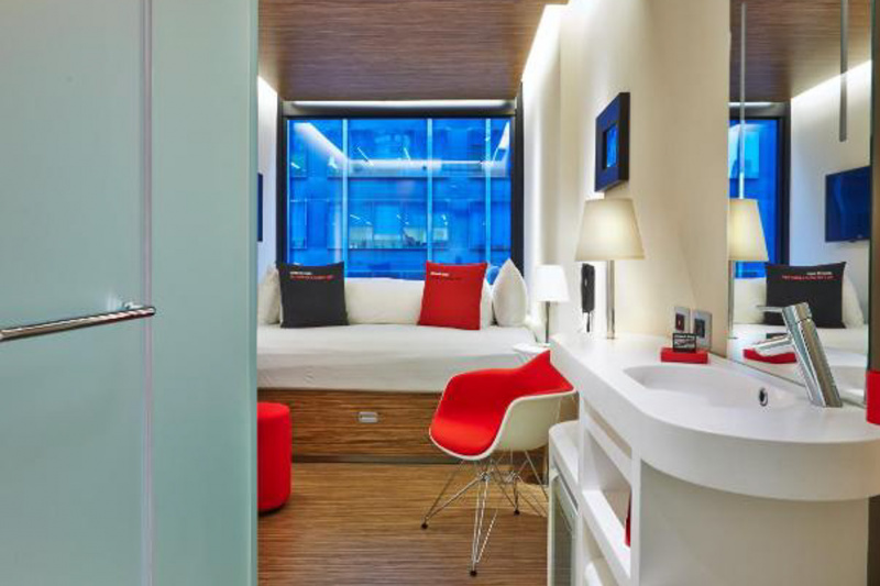 Bedroom with large double bed, sink, seating area and telephone