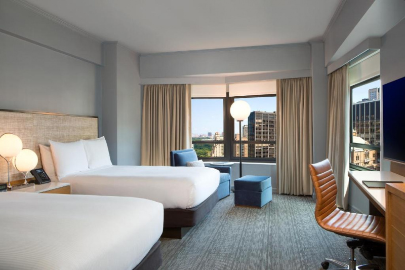 This spacious room has 2 double beds, seating area by the window, work desk and flat-screen TV
