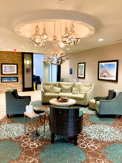 Seating area with sofa and armchairs, featuring carpeted floor