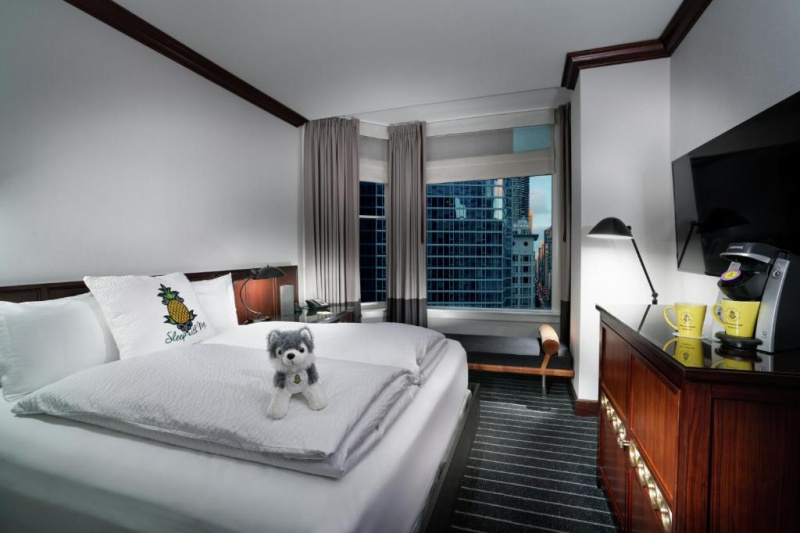 Deluxe Queen Room with a flat-screen TV and seat bench by the window