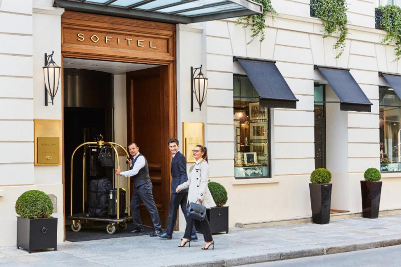 Hotel entrance with porter and luggage cart