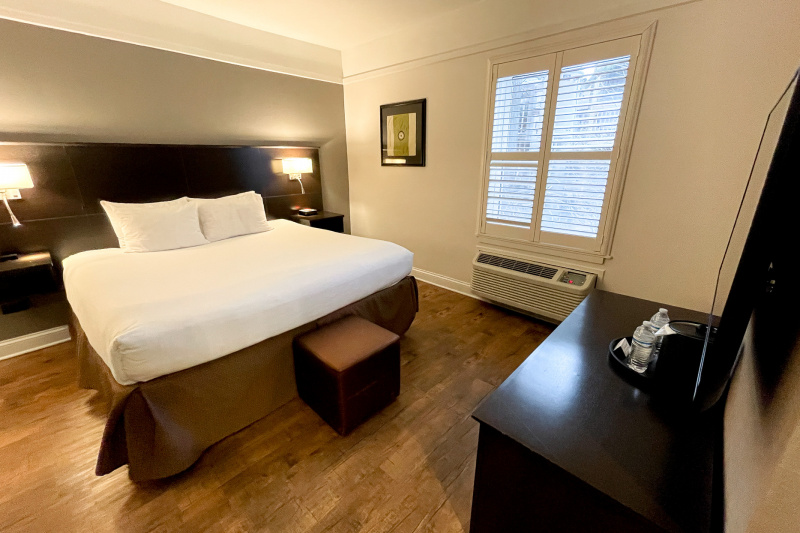 Guestroom with wooden flooring, bed and nightstands