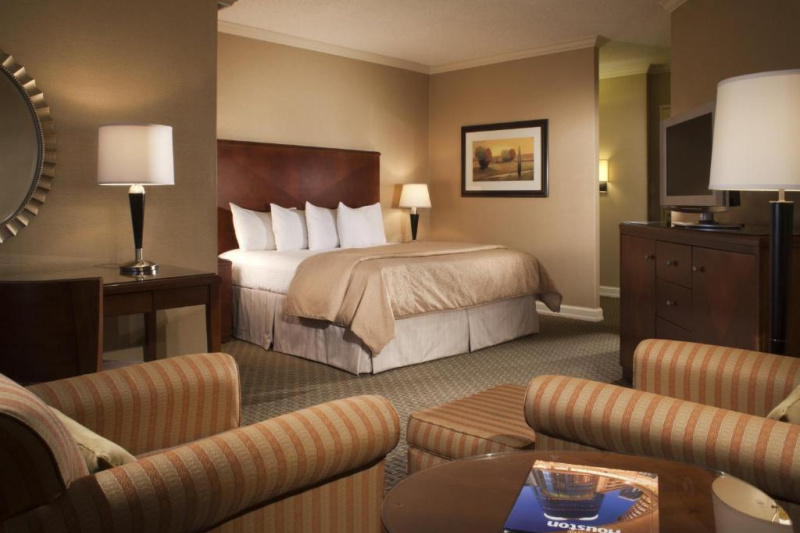 Guestroom with seating area, TV and bed