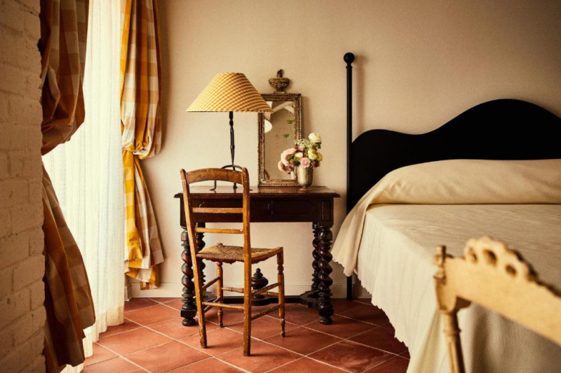 Guestroom with tiled floor, bed and bedside desk