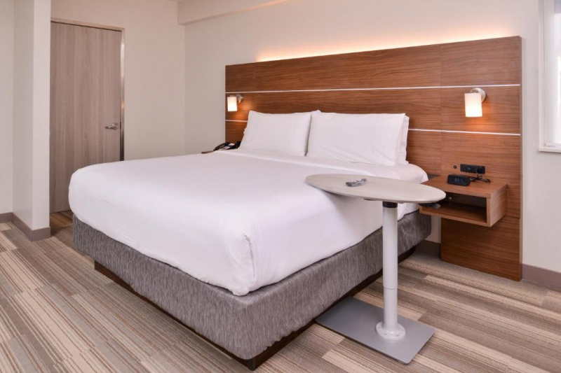 Guestroom with modern decor and bed with over-bed table