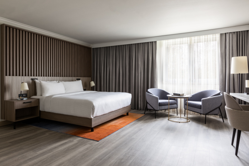 Guestroom with modern decor, bed and seating area