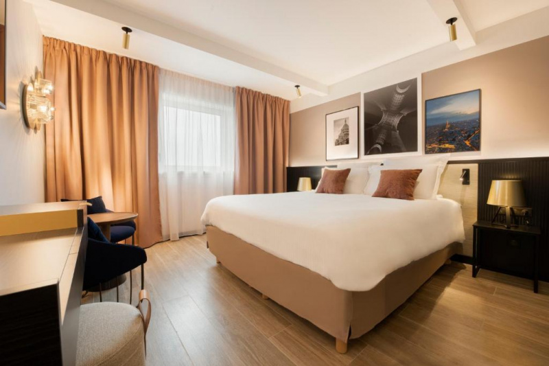 Guestroom with modern decor, bed with nightstands and desk