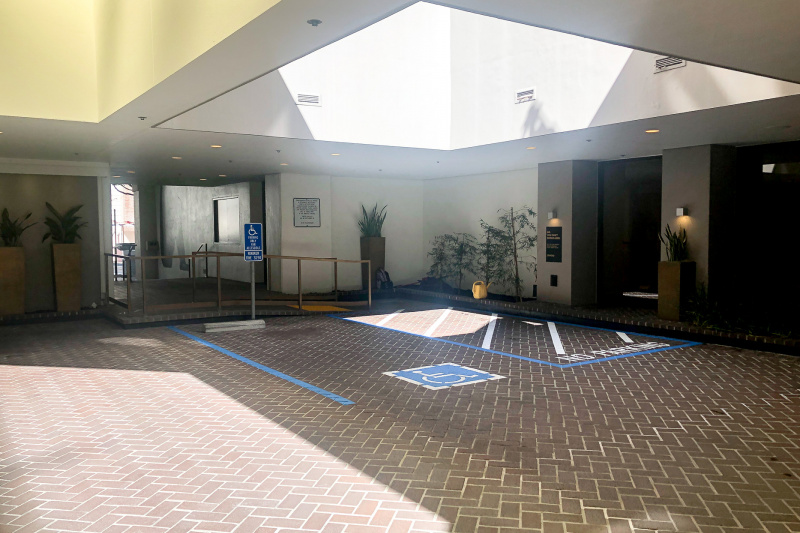 There is a blue badge disability parking bay, which is clearly marked. There is a ramp with handrails leading from the bay and away from the carpark.
