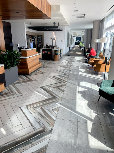 The lobby is spacious, with desks on one side and chairs on the other.
