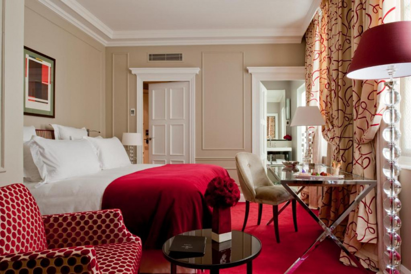 The accessible guest room, with a carpeted floor, a king-sized bed, and a seating area with an armchair