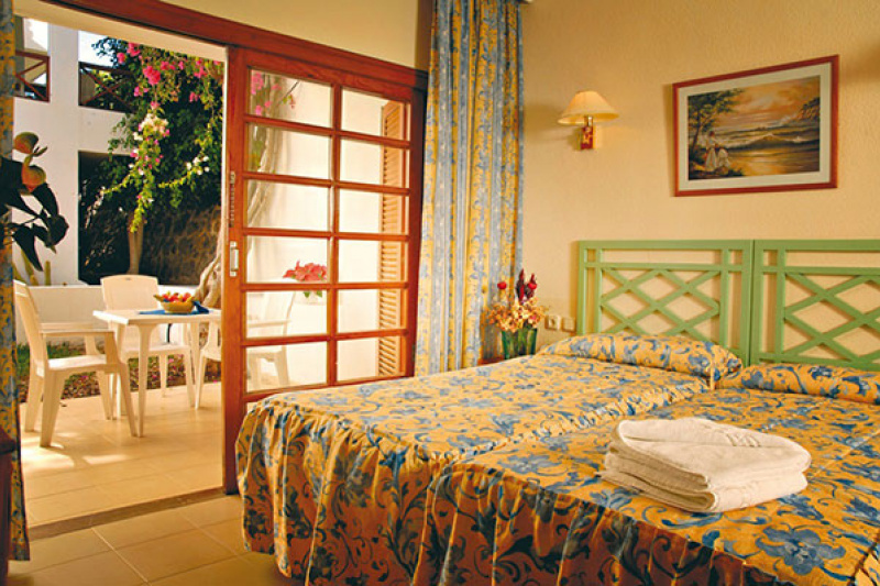 Guestroom with traditional decor, bed and sliding doors leading to the terrace
