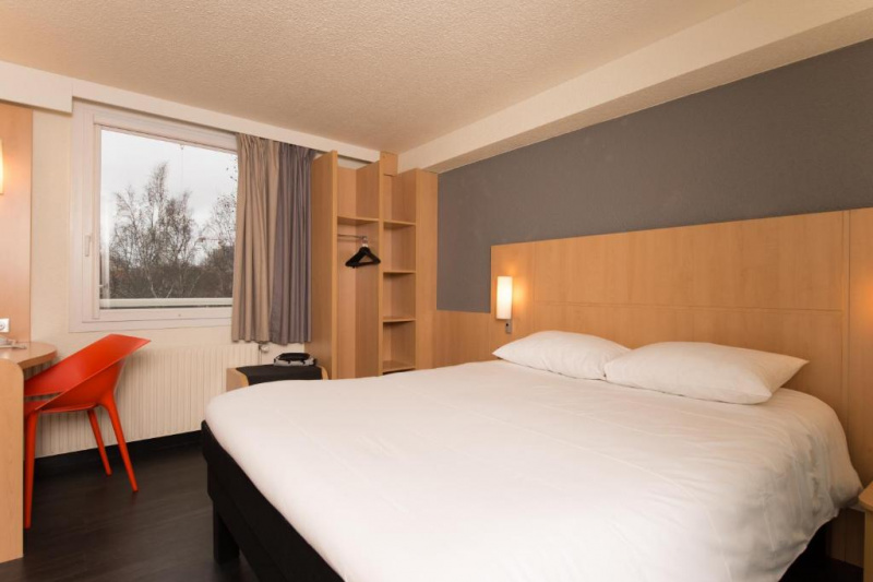 Guestroom with modern decor, bed and open-front closet