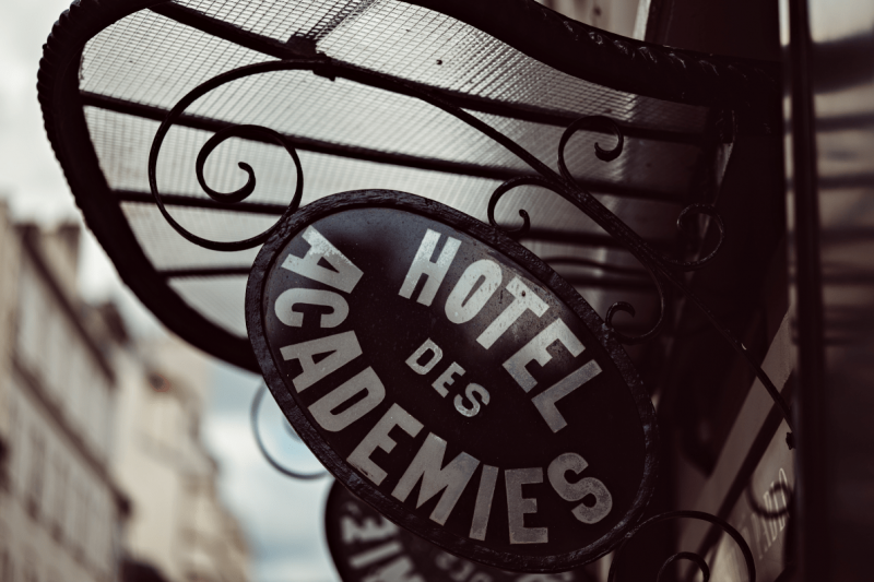 The name of the hotel is printed on an art deco-style wrought iron door canopy.