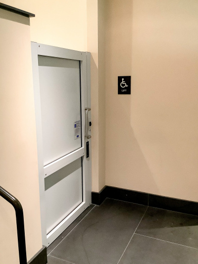 The spacious covered open-sided lobby has several reception desks, one with a dropped counter for wheelchair access. There is comfortable seating overlooking the outdoor waterfall feature.