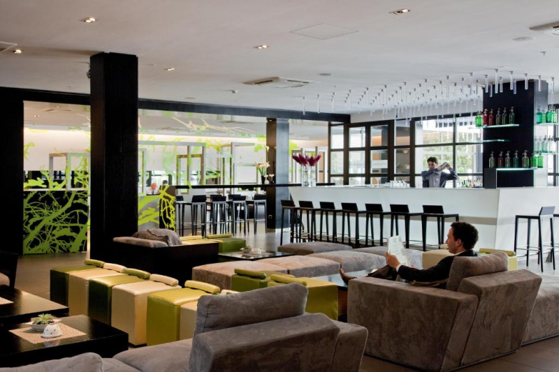 The bar and lounge has high and low seating areas. There are moveable bar stools at the bar and a separate high counter. The lounge area has large, low plush armchairs and banquettes and small leather banquettes arranged around low coffee tables..