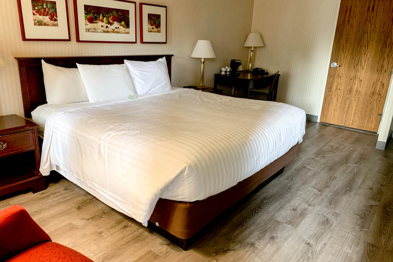 The king bed room has a king-sized bed, nightstands and a desk with a coffee machine and telephone.