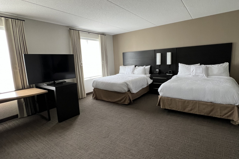 The 2 queen studio has two queen-sized beds with integral reading lights over a central nightstand with telephone, large windows, a flat screen TV and a desk.