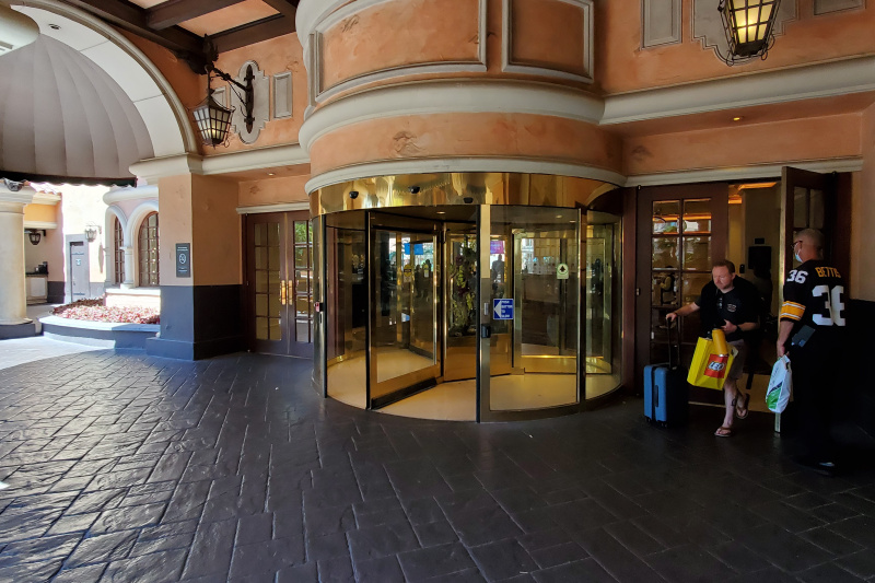 Covered entrance with a revolving door flanked by two sets of double doors all providing step-free access.