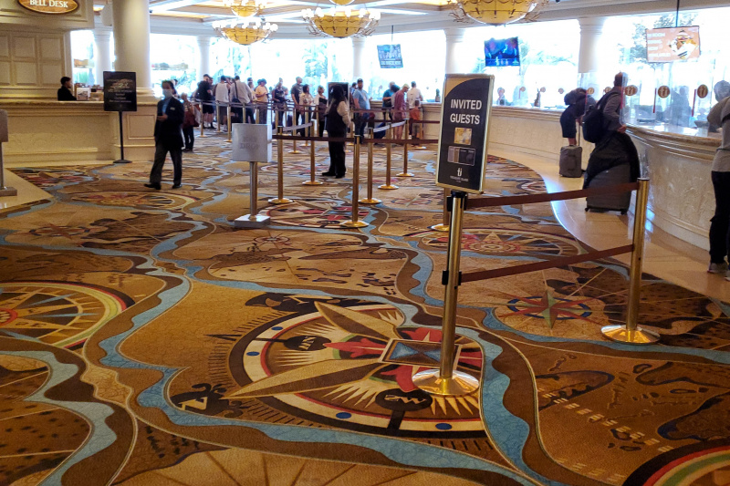 Spacious and well-lit entrance lobby with smooth map-design carpet and check-in queue.