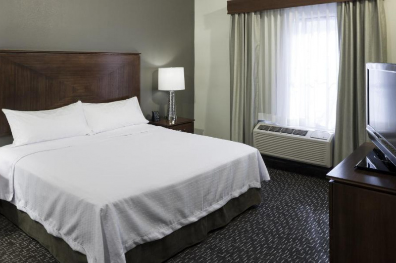 The king 1-bedroom suite has a separate bedroom with a king-sized bed, nightstands and a free-standing TV on a cabinet.
