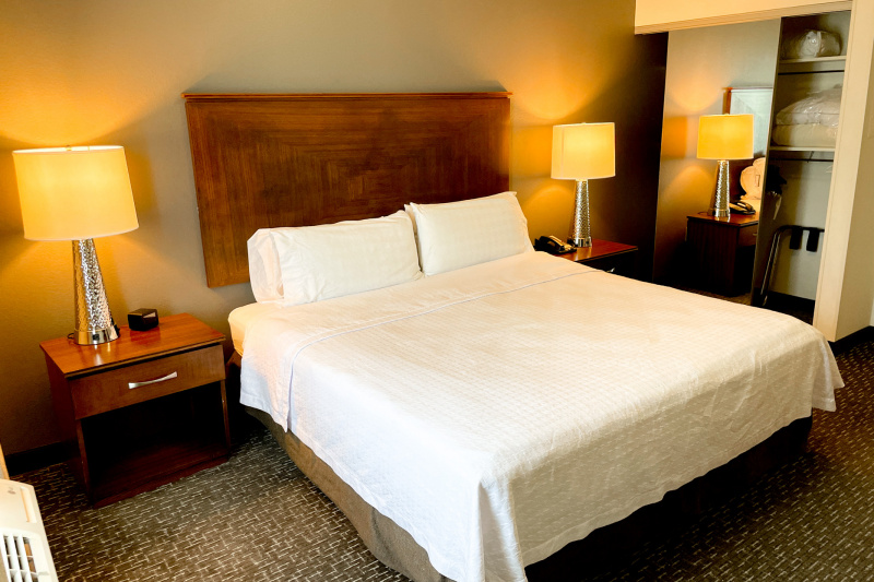The king 1-bedroom suite has a king-sized bed, nightstands with alarm clock and telephone and a roll-in closet with a mirrored sliding door.