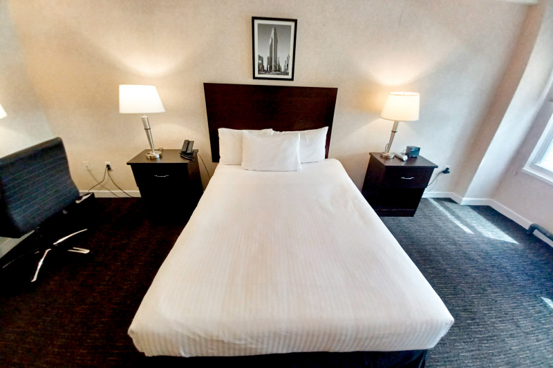 The Signature queen room has a queen-sized bed, bedside consoles with telephone and alarm clock and an executive chair.