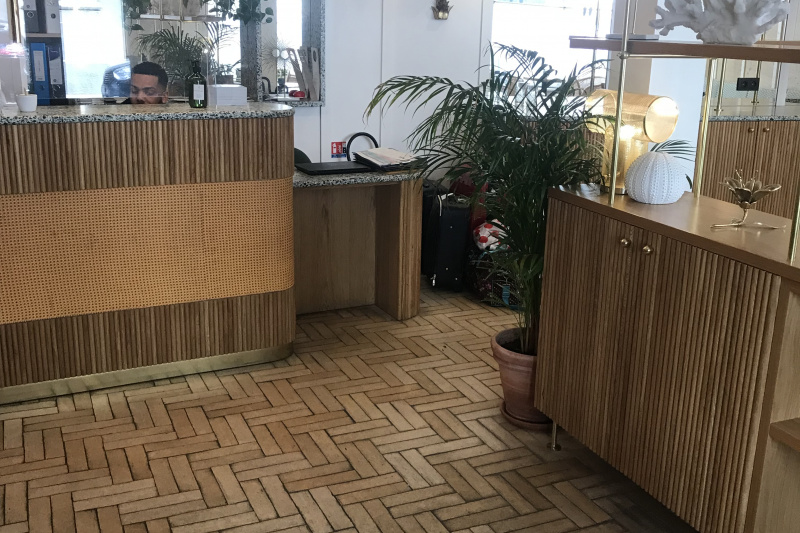 The reception area has a lowered counter section for wheelchair accessibility and designer lamps and house plants.