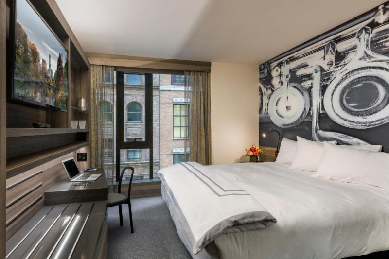 The superior king room has a king-sized bed, desk and chair and a large TV and artwork on the wall.