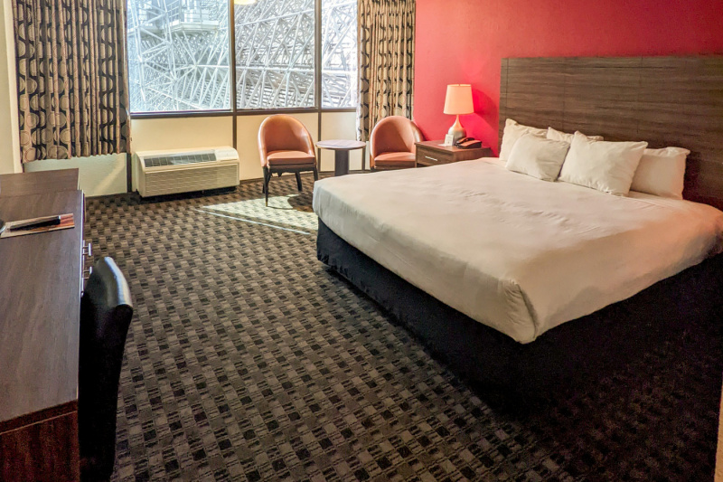 The Deluxe king room has a king-sized bed, a seating area with two chairs and a table. There is also a spacious desk and chair.