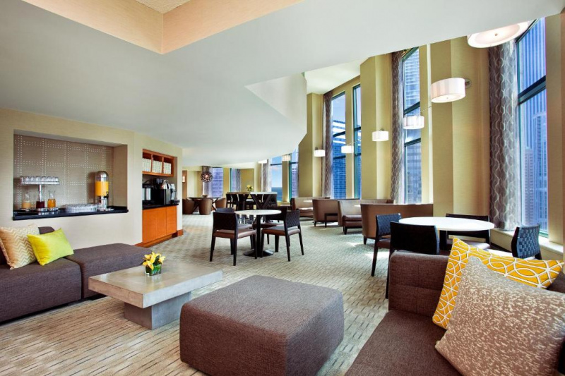 The spacious Lobby West features an assortment of round tables with moveable chairs, and comfortable sofas and banquette seats arranged around low coffee tables. There are accessible coffee/tea machines and juice dispensers to one side..